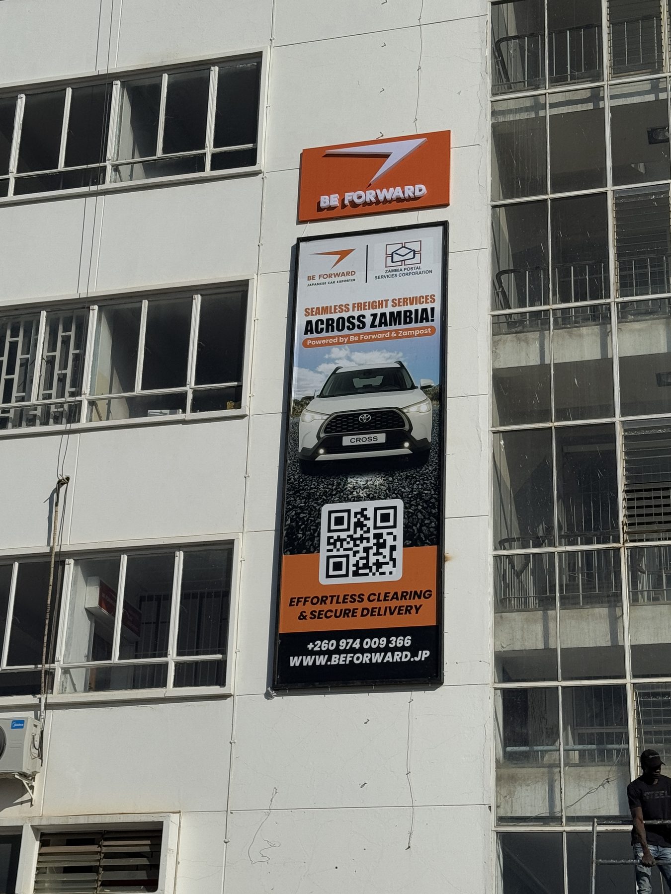 BE FORWARD campaign banner on an office building